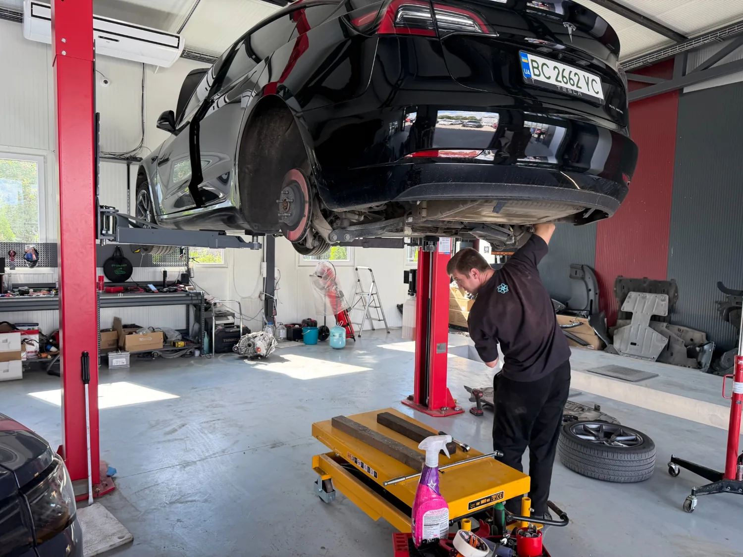 Tesla Model Y на подъёмнике: автомобиль в процессе сервисных работ.